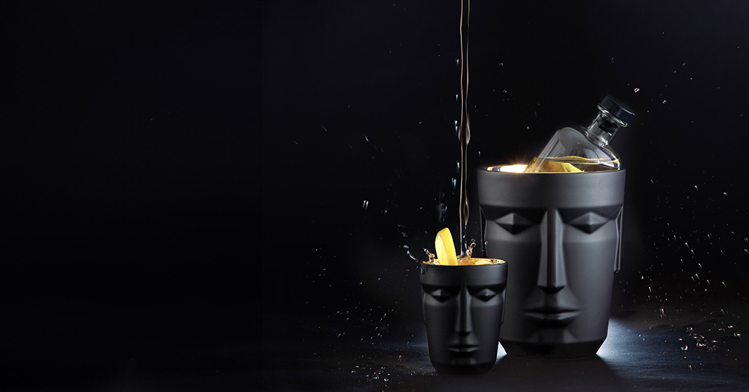 Zwei maskenförmige Becher mit Getränken, dunkler Hintergrund, stilvoll präsentiert. Fürstenberg Porzellan.