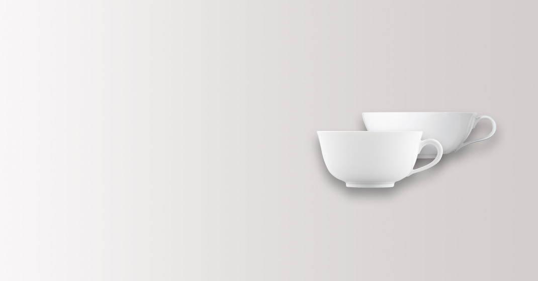 Zwei weiße Porzellantassen in minimalistischem Design auf grauem Hintergrund. Fürstenberg Porzellan.