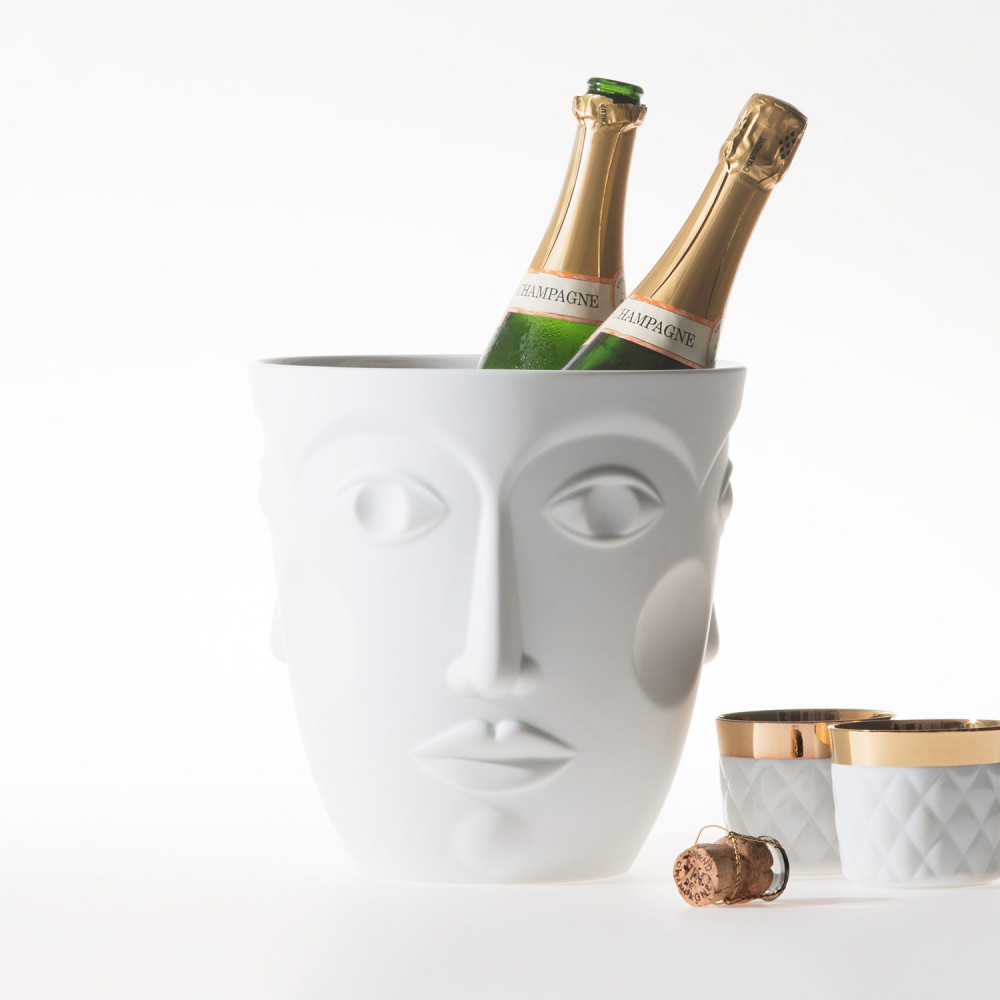 Porzellankopfgefäß hält zwei Champagnerflaschen, daneben zwei Becher und Korken. Fürstenberg Porzellan.