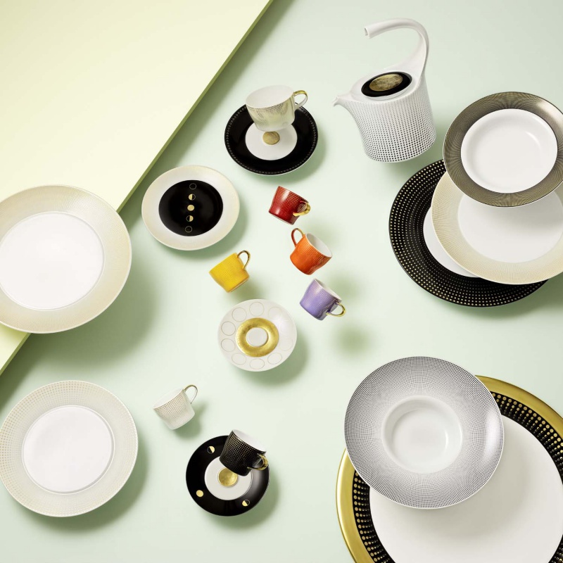 img2_ta20148_7000_teetasse_2_tlg Verschiedene bunte Tassen und Teller arrangiert auf pastellgrünem Hintergrund. Fürstenberg Porzellan.