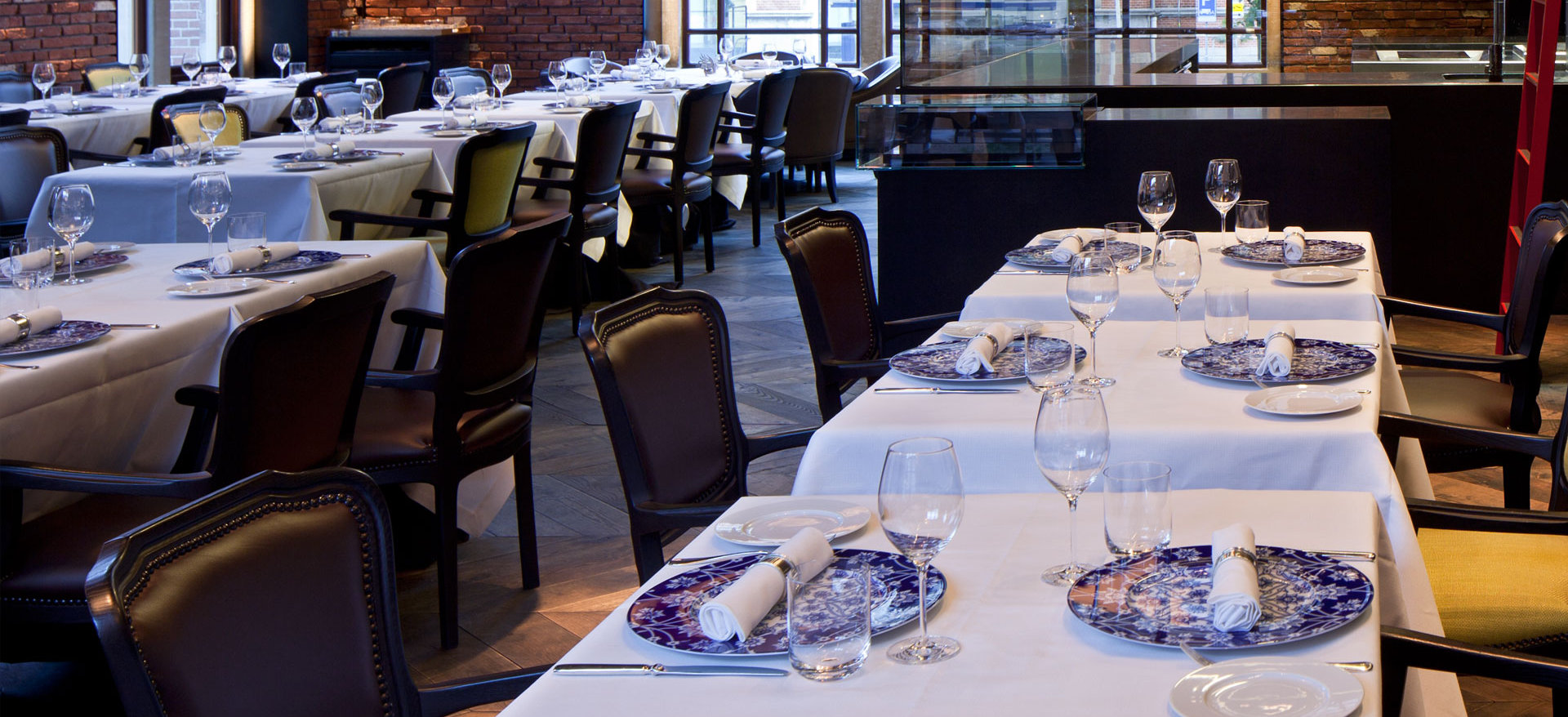 Weiß gedeckte Tische mit blauem Porzellan in elegantem Restaurant. Fürstenberg Porzellan.