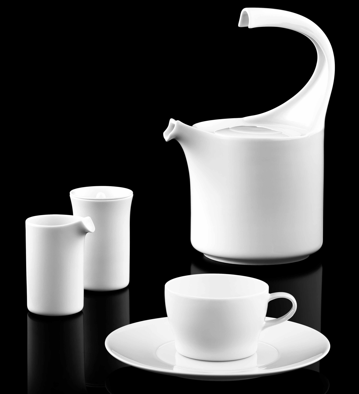 Weißes Porzellan-Set aus Kanne, Becher, Tasse auf schwarzem Hintergrund. Fürstenberg Porzellan.