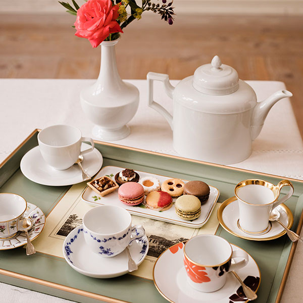 Tablett mit Tassen, Teekanne und Gebäck in eleganter Tischdekoration. Fürstenberg Porzellan.