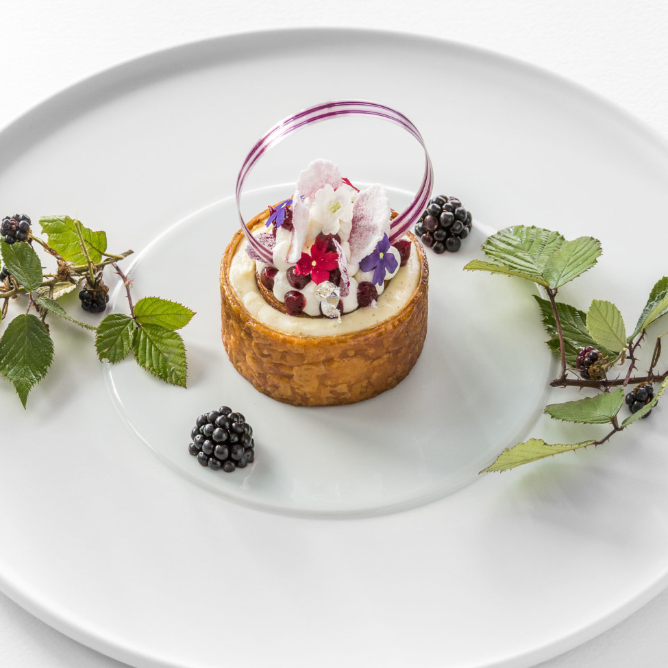 Kuchen dekorierter Teller mit Blumen und Brombeeren, serviert mit Blättern. Fürstenberg Porzellan.