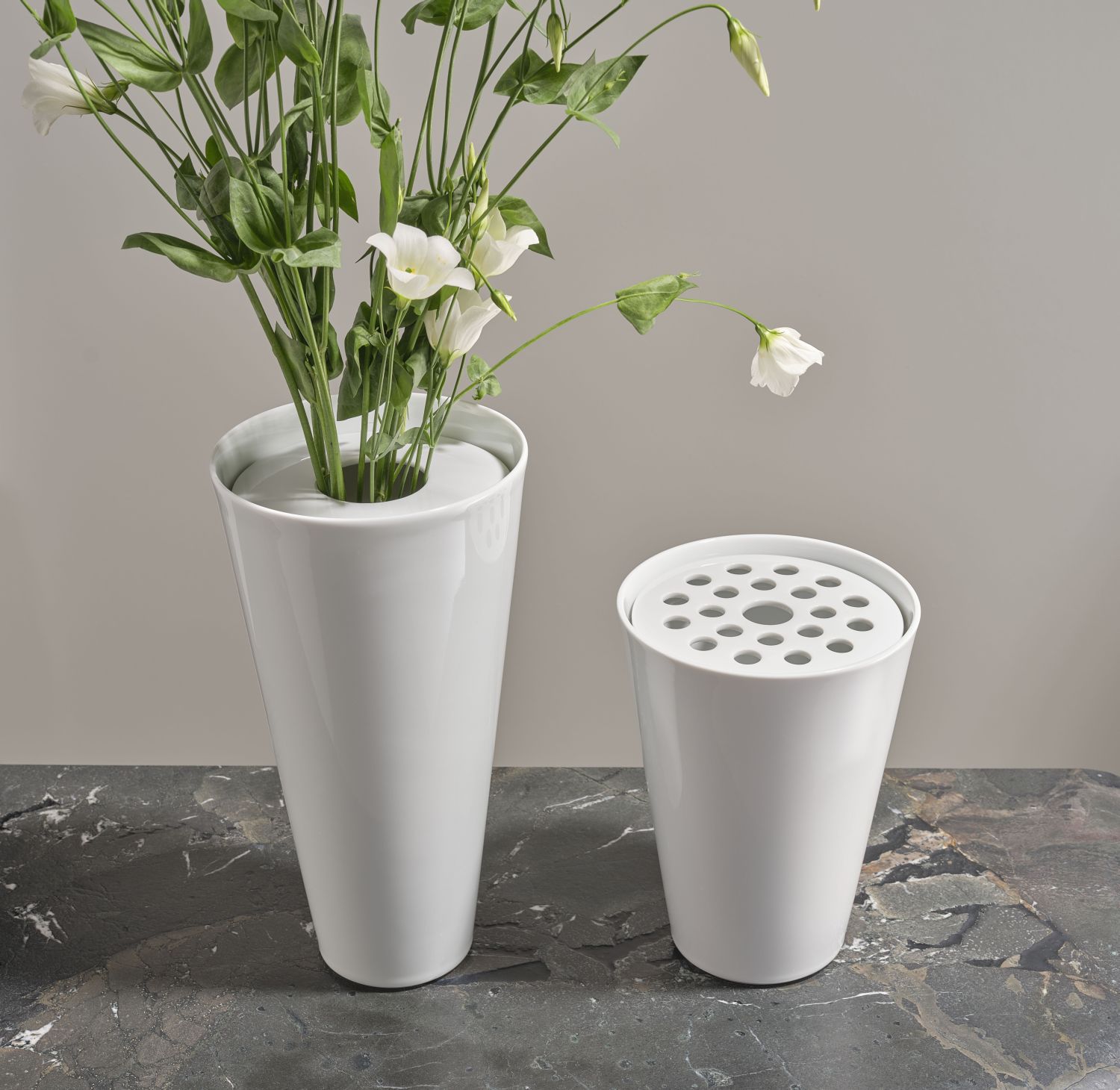 Zwei weiße Vasen stehen auf Marmortisch; eine hält Blumen. Fürstenberg Porzellan.