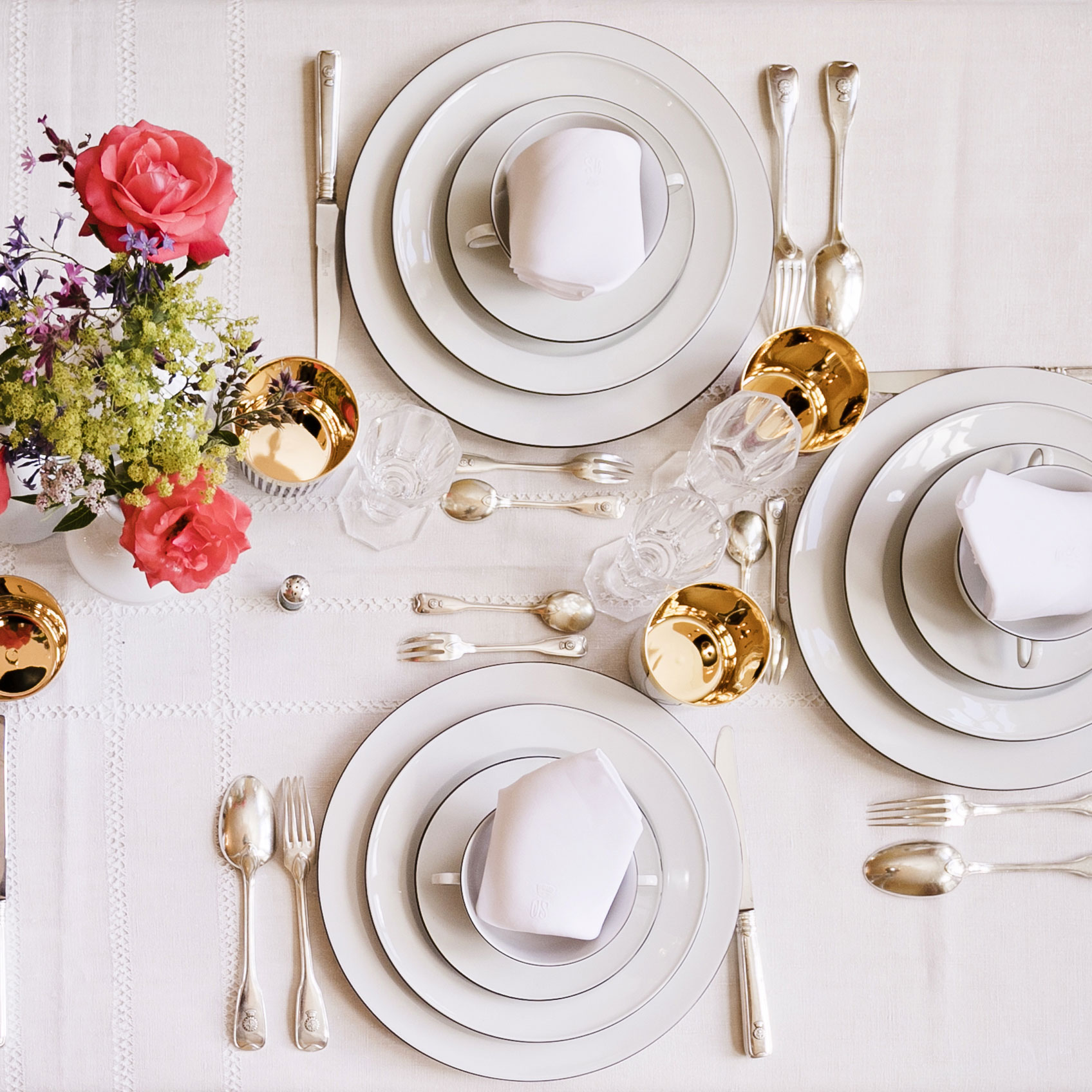 Zwei elegant gedeckte Gedecke mit Besteck und Blumenvase auf weißer Tischdecke. Fürstenberg Porzellan.