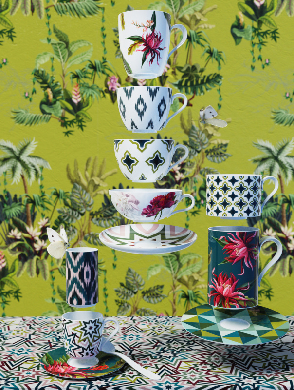 img2_ob2007195712_kaffeebecher Tassen und Untertassen stapeln sich schwebend vor floralem Hintergrund mit Schmetterlingen. Fürstenberg Porzellan.