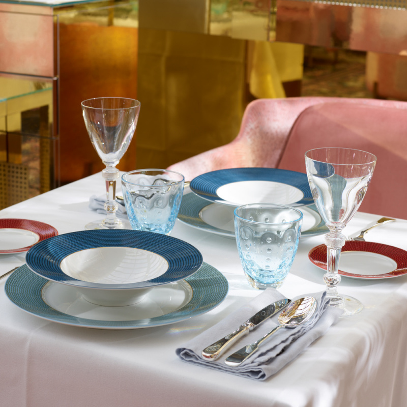 img2_tf2011225904_teller_tief Tischgedeck mit blauem und rotem Geschirr, zwei Gläsern in elegantem Ambiente. Fürstenberg Porzellan.