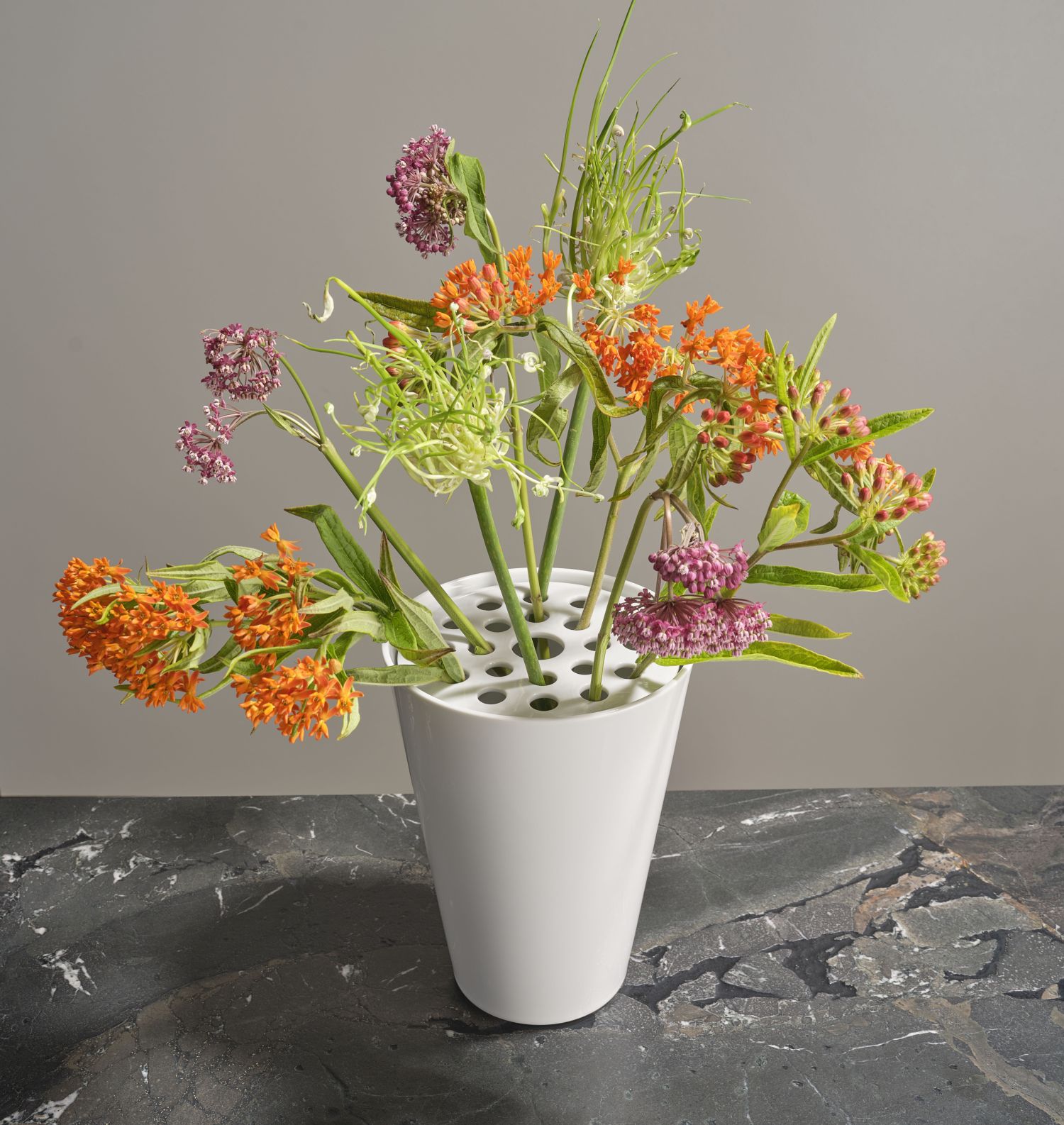 Weiße Vase mit bunten Blumen auf dunklem Marmortisch stehend. Fürstenberg Porzellan.