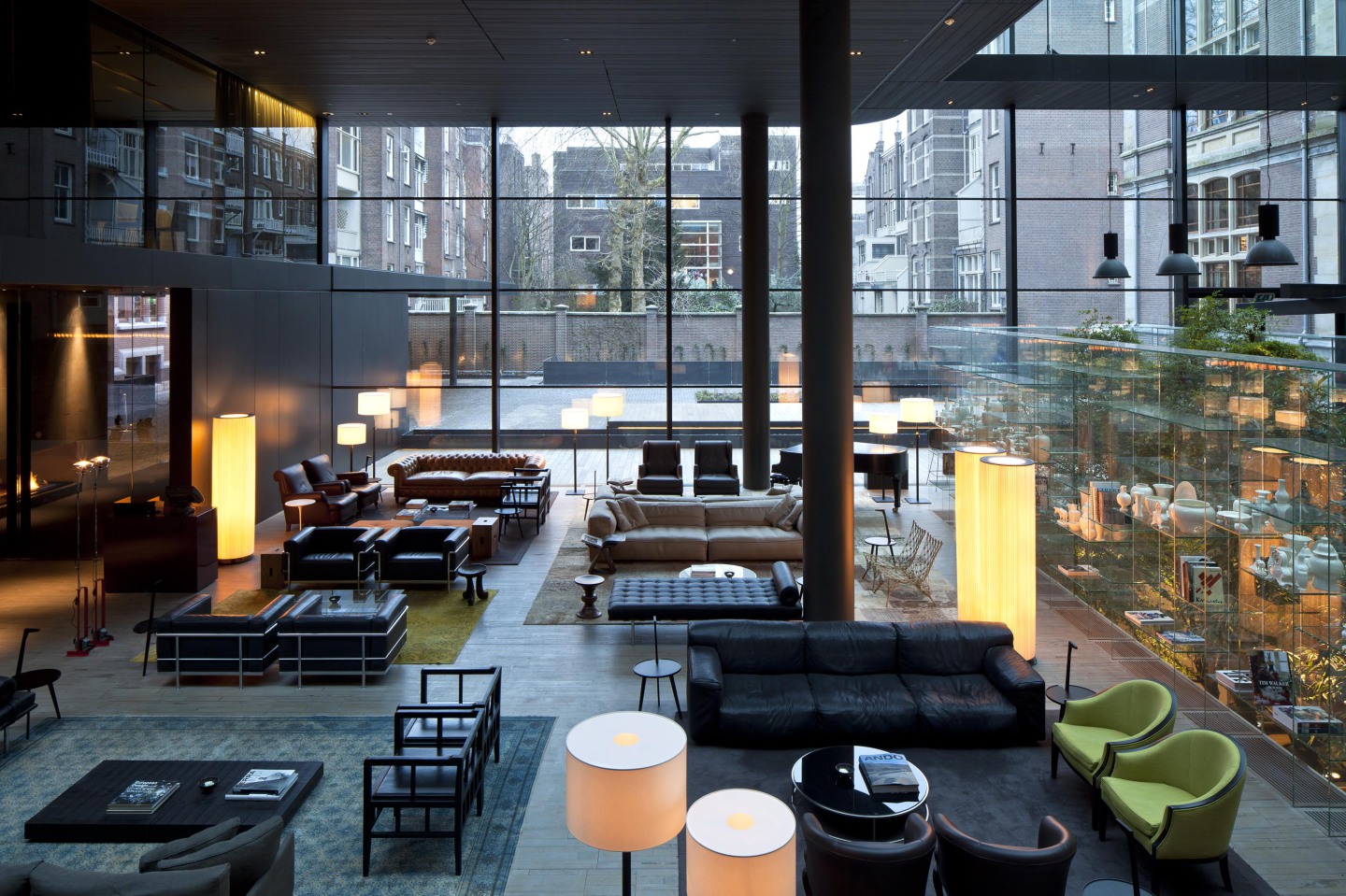 Großer, moderner Loungebereich mit Ledersofas, Glaswänden, Lampen, Stadtblick im Hintergrund. Fürstenberg Porzellan.