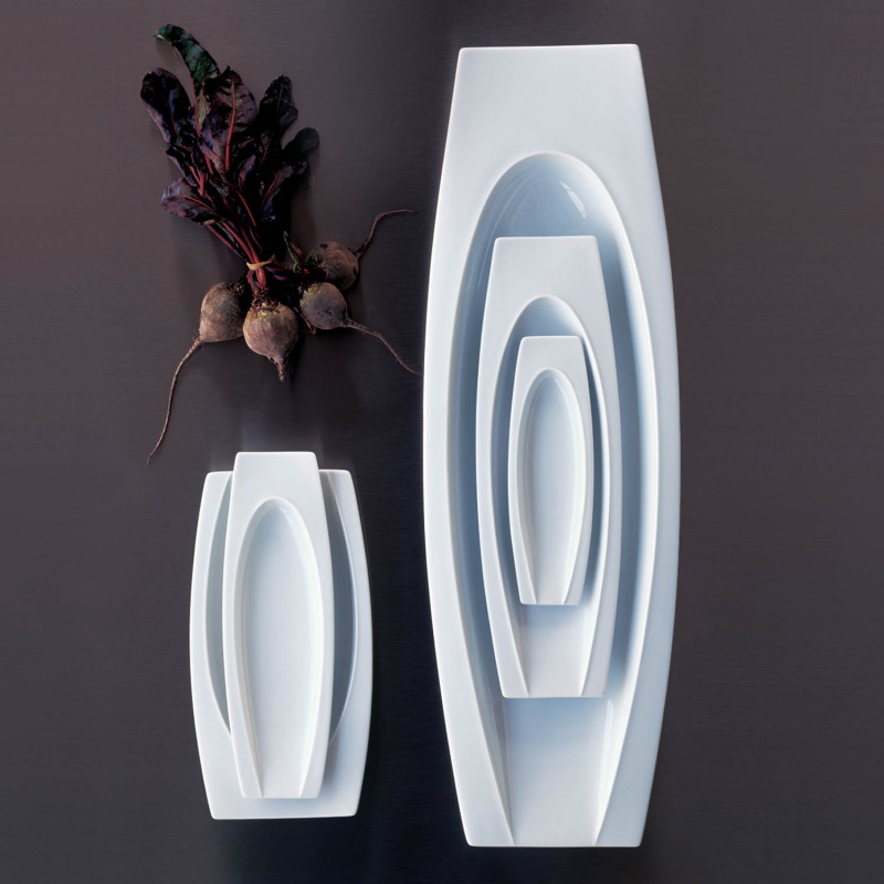 img2_sc200550weiss_schale Weiße, gestapelte Porzellanschalen neben frischen Rüben auf einem dunklen Hintergrund. Fürstenberg Porzellan.