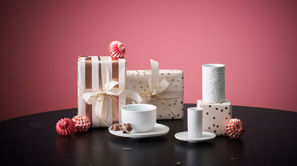 Geschenkpäckchen mit weißem Porzellantassen davor