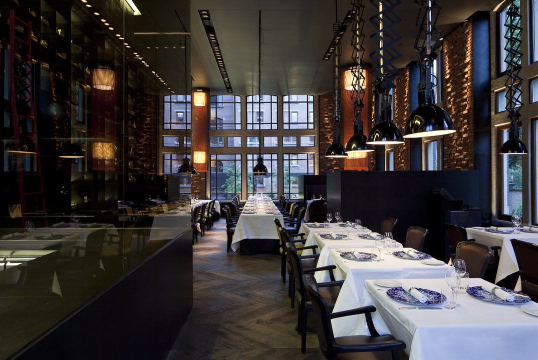 Elegantes Restaurant mit gedeckten Tischen und großen Fenstern, Porzellangeschirr sichtbar. Fürstenberg Porzellan.