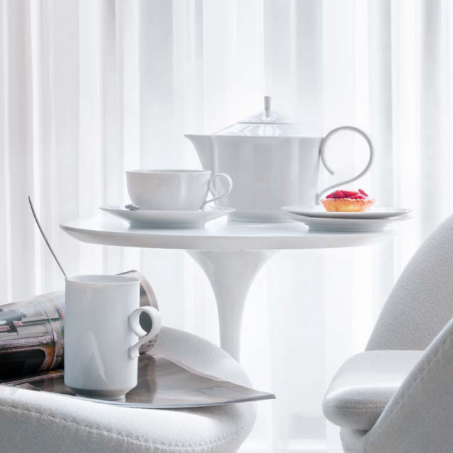 Teekanne, Tasse und Gebäck auf weißem Tisch vor hellem Vorhang. Fürstenberg Porzellan.