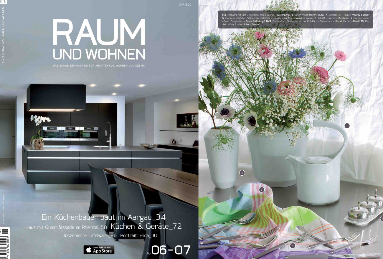 Moderne Küche mit dunklem Design, heller Raum, stilvolle Blumenvasen. Fürstenberg Porzellan.