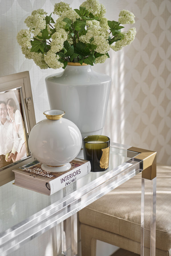 Weiße Vase mit Blumen steht auf Glastisch neben Foto und Büchern, "INTERIORS NOW!". Fürstenberg Porzellan.