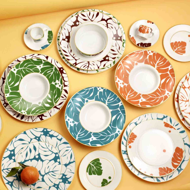img5_fl20143270023_platzteller Bunte Teller mit Blattmustern liegen auf gelbem Hintergrund. Fürstenberg Porzellan.