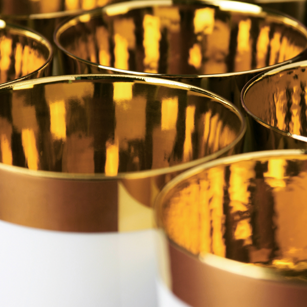 Nahaufnahme von goldenen, reflektierenden Porzellantassen in eleganter Anordnung. Fürstenberg Porzellan.