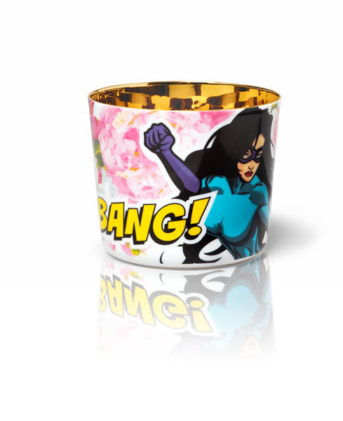 Becher mit Comic-Heldin, rosa Blumen, Text "BANG!" auf weißem Hintergrund. Fürstenberg Porzellan.