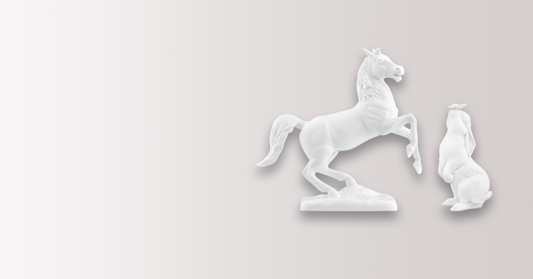 Weiße Porzellanfiguren: Ein steigendes Pferd und ein sitzender Hase nebeneinander. Fürstenberg Porzellan.
