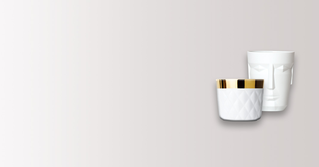 Zwei weiße Tassen, eine mit goldener Verzierung im Vordergrund, minimalistisch gestaltet. Fürstenberg Porzellan.