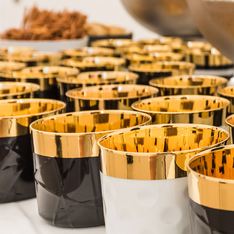 img2_ob17853_6038_champagnerbecher_white__moon__punkterelief Goldene, glänzende Porzellanbecher mit Reliefmuster, dicht angeordnet auf Tisch. Fürstenberg Porzellan.