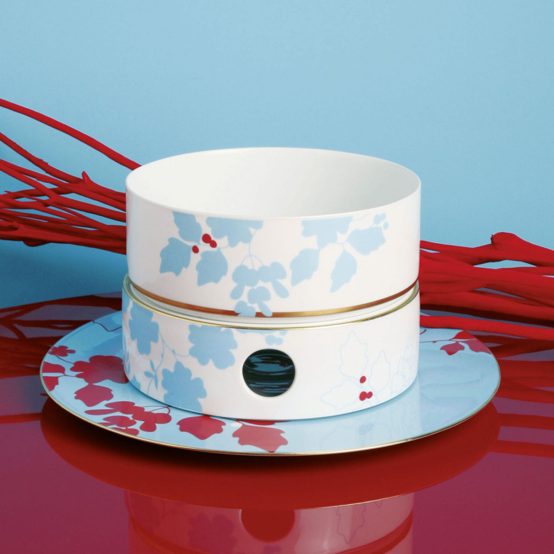 img3_fl2006325700_platzteller Weiße Porzellanschale auf Teller mit blauen, roten Blättern, Hintergrund: rote Zweige. Fürstenberg Porzellan.