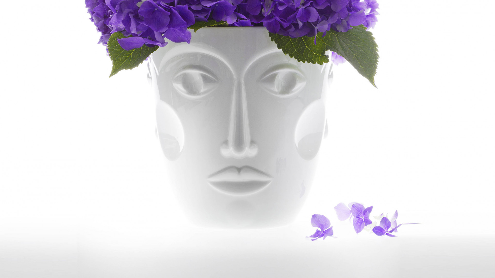 Weiße Gesichts-Vase mit lila Blüten dekoriert, strahlt Eleganz aus. Fürstenberg Porzellan.