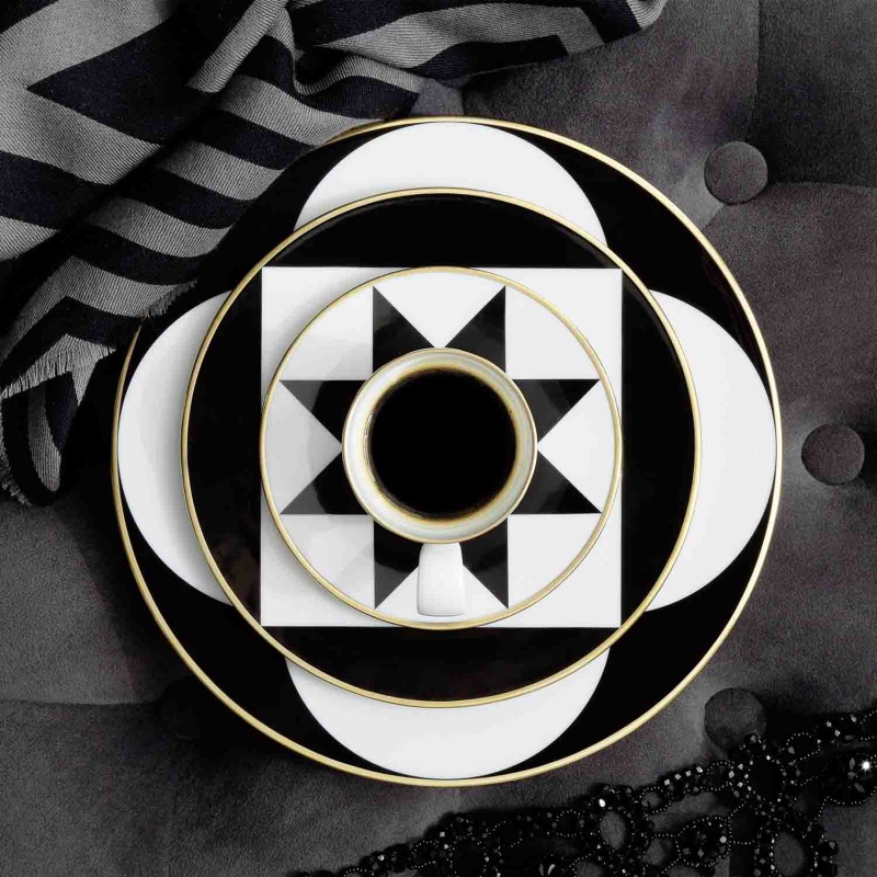 img2_un20067_5705_espressountertasse Schwarz-weiße geometrische Tassen und Teller auf gestreiftem Stoff arrangiert. Fürstenberg Porzellan.