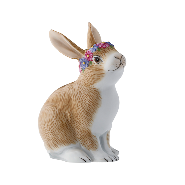 Porzellan-Hase mit Blumenkranz sitzt aufmerksam auf weißem Hintergrund. Fürstenberg Porzellan.