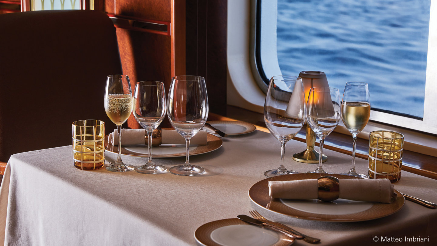 Elegant gedeckter Tisch mit Weingläsern, am Fenster eines Schiffsrestaurants. Fürstenberg Porzellan.