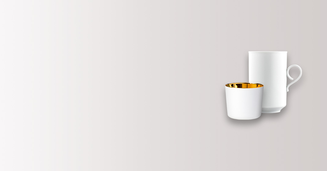Weiße Tasse und Becher mit goldener Innenverkleidung, auf grauem Hintergrund. Fürstenberg Porzellan.