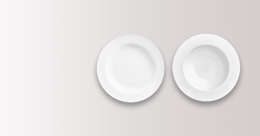 Zwei weiße Porzellanteller nebeneinander auf einem hellgrauen Hintergrund. Fürstenberg Porzellan.