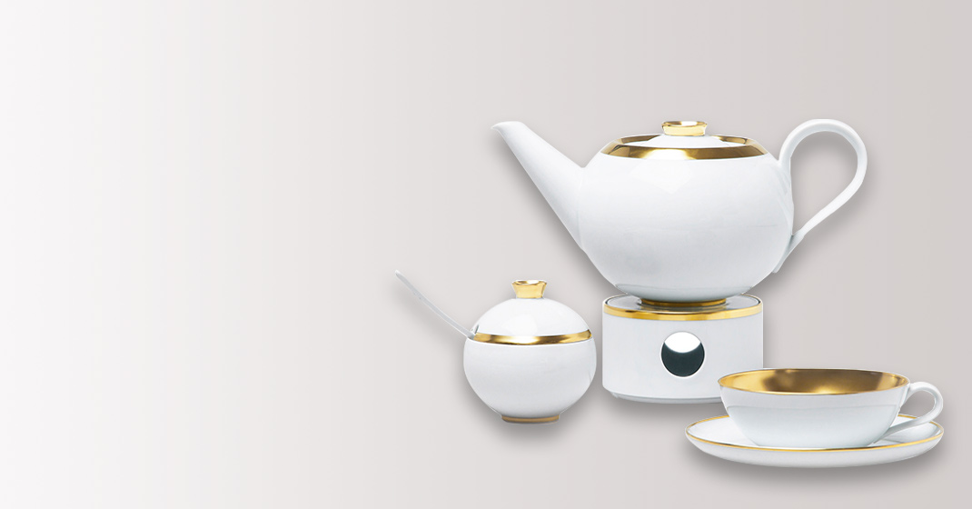 Weißes Teeservice mit goldenen Akzenten, bestehend aus Kanne, Zuckerdose, Tasse. Fürstenberg Porzellan.