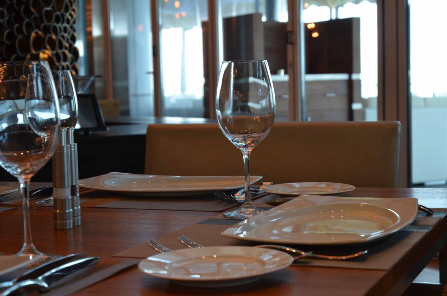 Gedeckter Esstisch mit Weingläsern und Tellern in elegantem Restaurant. Fürstenberg Porzellan.