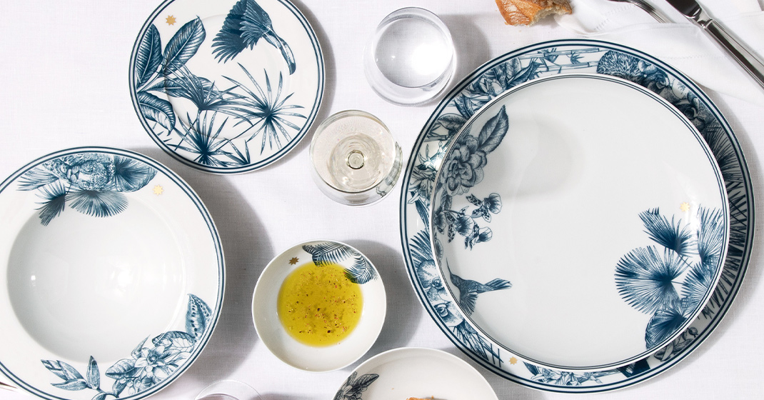 Porzellanteller mit blauen Naturmotiven, dekorativ auf Tisch mit weißen Tischtuch. Fürstenberg Porzellan.