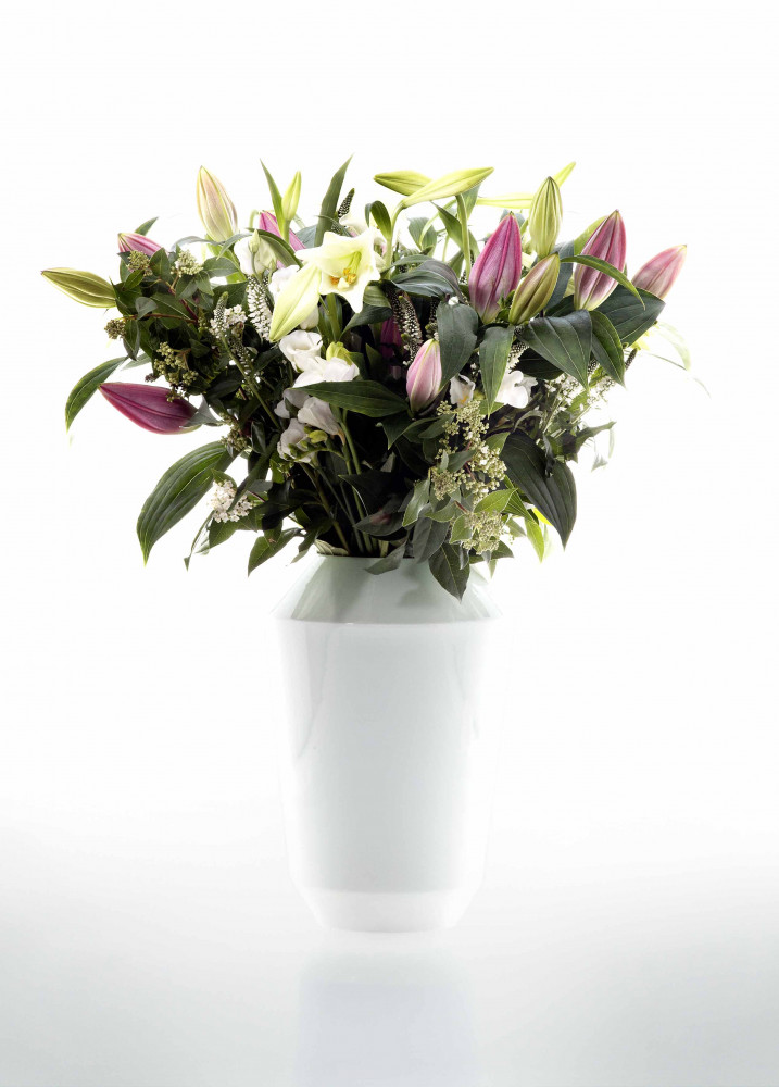 Weiße Vase mit Strauß aus rosa und weißen Lilien auf hellem Hintergrund. Fürstenberg Porzellan.