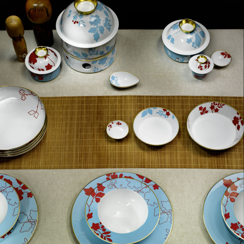 img2_tf2007265700_pastateller Porzellangeschirr mit blau-rotem Blattmuster und goldenen Akzenten, auf Bambusunterlage arrangiert. Fürstenberg Porzellan.