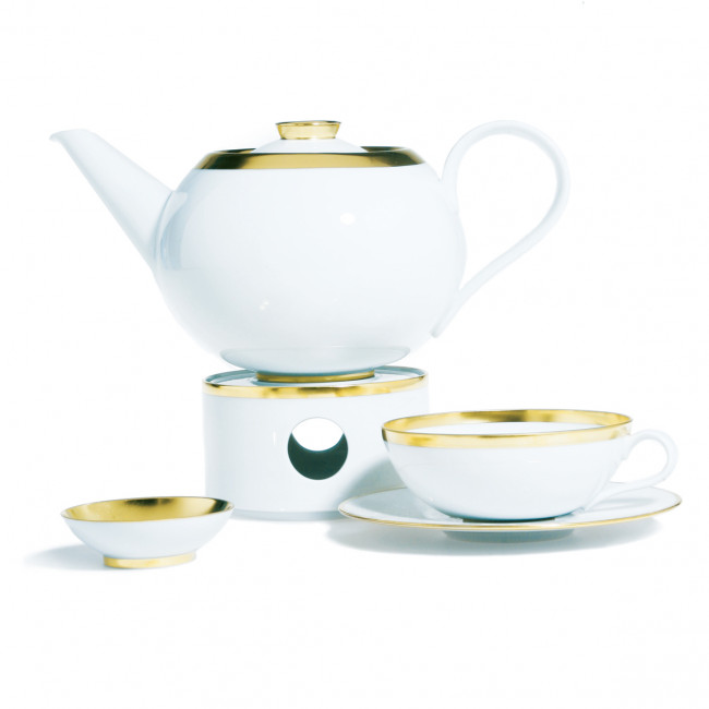 Teekanne mit goldener Verzierung auf Stövchen, Tasse und Schale daneben. Fürstenberg Porzellan.