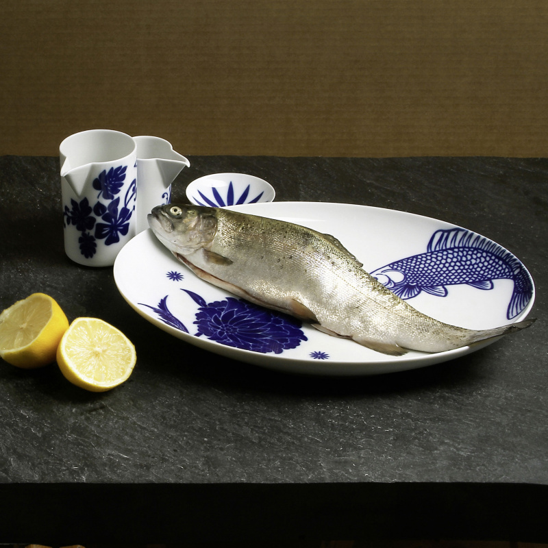 img3_ko20078_5704_schale_xs Fisch liegt auf blau-weißem Porzellanteller mit Zitronen und Milchkanne. Fürstenberg Porzellan.