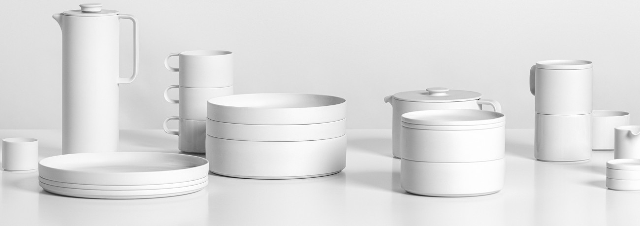 Weiße Porzellan-Geschirrset mit Tassen, Tellern, Schüsseln und Kannen auf Tisch. Fürstenberg Porzellan.