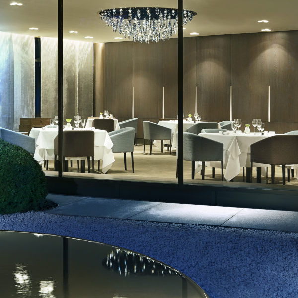 Elegantes Restaurant mit gedeckten Tischen, Blick durch Glaswand. Fürstenberg Porzellan.