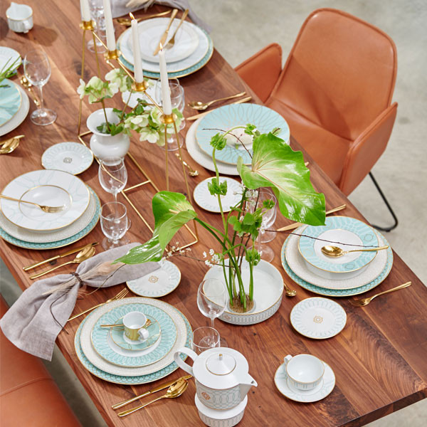 Elegante Dinnertafel mit weiß-blauem Geschirr, goldenen Bestecken und Kerzen. Fürstenberg Porzellan.