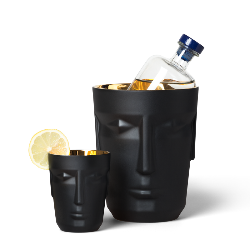 img2_bk1882206103_ice_bucket_prometheus__mattsatiniert__schwarz Schwarzer Gesichtseimer hält Flasche; kleines Glas mit Zitronenscheibe daneben. Fürstenberg Porzellan.