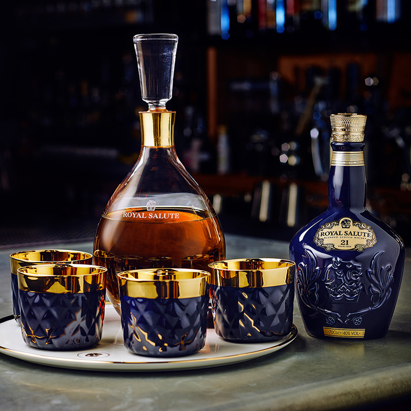 Karaffe und Flasche mit "Royal Salute" Whisky, vier goldrandige Gläser, Barhintergrund. Fürstenberg Porzellan.