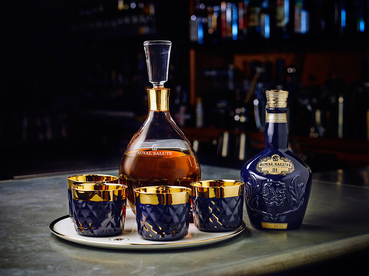Whiskyflasche und Dekanter "Royal Salute" stehen auf Bartresen, daneben vier Gläser. Fürstenberg Porzellan.