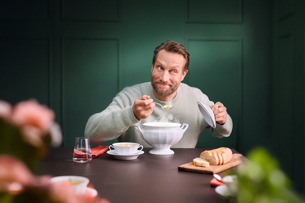 Weiße Porzellan-Suppenschale der FÜRSTENBERG Kollektion Grecque Weiß im Einsatz beim Servieren einer Suppe an einem stilvoll gedeckten Tisch.