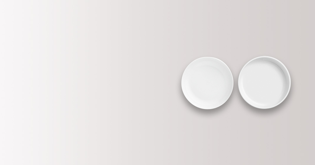 Zwei weiße Porzellanteller, nebeneinander liegend, vor grauem Hintergrund. Fürstenberg Porzellan.