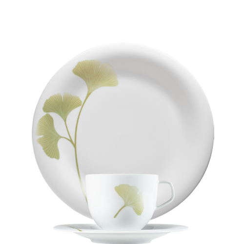 Weiße Tasse, Teller mit grünem Ginkgo-Design auf weißem Hintergrund. Fürstenberg Porzellan. Weiße Tasse, Teller mit grünem Ginkgo-Design auf weißem Hintergrund. Fürstenberg Porzellan.