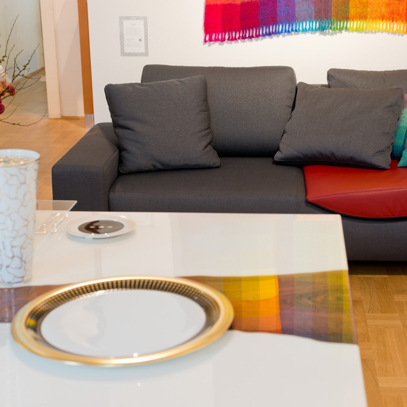 img3_fl2014187000_brotteller Teller auf weißem Tisch vor grauem Sofa mit buntem Tuch. Fürstenberg Porzellan.